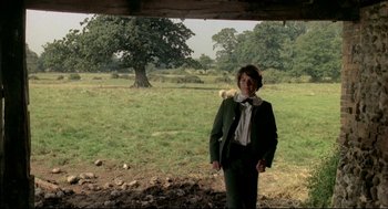 Movie still from “The Go-Between” (1971), directed by Joseph Losey – A man in a suit standing in front of a tree; Wide shot, Over the shoulder angle