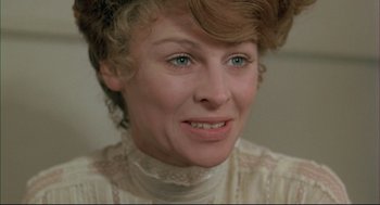 Movie still from “The Go-Between” (1971), directed by Joseph Losey – An older woman in a white dress with blue eyes; Close Up shot, Low angle