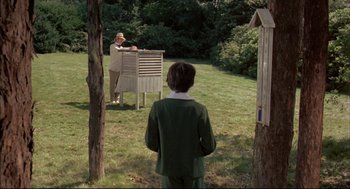 Movie still from “The Go-Between” (1971), directed by Joseph Losey – Two people in a field playing a game of whack - a - mole; Wide shot, Low angle
