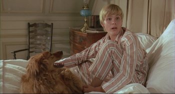 Movie still from “The Go-Between” (1971), directed by Joseph Losey – A boy and a dog laying on a bed; Medium shot, High angle