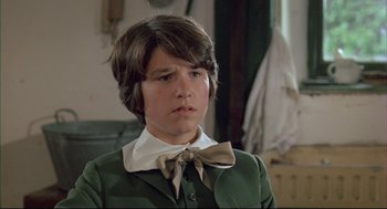 Movie still from “The Go-Between” (1971), directed by Joseph Losey – A young man in a green suit and a bow tie; Close Up shot, Over the shoulder angle
