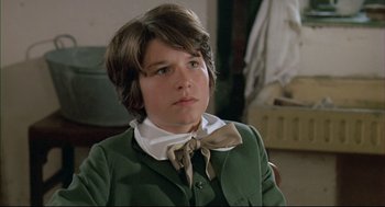 Movie still from “The Go-Between” (1971), directed by Joseph Losey – A young boy wearing a green jacket and a bow tie; Close Up shot, High angle