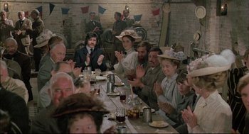 Movie still from “The Go-Between” (1971), directed by Joseph Losey – A group of people sitting at a long dinner table; Wide shot, Over the shoulder angle