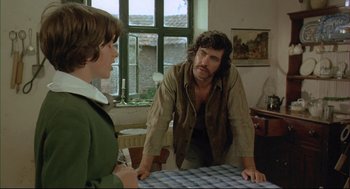 Movie still from “The Go-Between” (1971), directed by Joseph Losey – A man and a woman standing in front of a table in a room; Medium shot, Over the shoulder angle