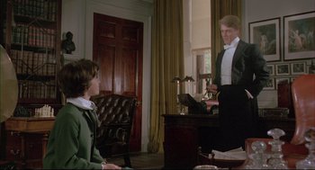 Movie still from “The Go-Between” (1971), directed by Joseph Losey – A man in a suit and bow tie standing in front of a woman; Medium shot, Over the shoulder angle