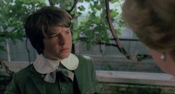 Movie still from “The Go-Between” (1971), directed by Joseph Losey – A young man wearing a green suit and white collar; Close Up shot, Over the shoulder angle