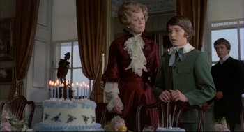 Movie still from “The Go-Between” (1971), directed by Joseph Losey – A woman and a young boy standing in front of a cake; Medium shot, Over the shoulder angle