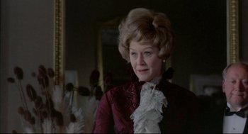 Movie still from “The Go-Between” (1971), directed by Joseph Losey – An older woman in a red and white dress; Close Up shot, Over the shoulder angle