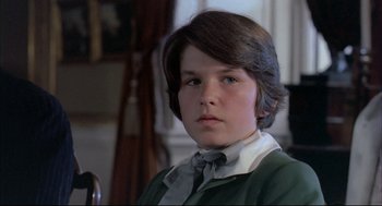 Movie still from “The Go-Between” (1971), directed by Joseph Losey – A young boy with long hair wearing a green shirt; Close Up shot, High angle