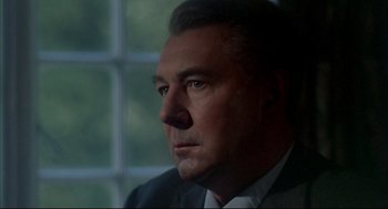 Movie still from “The Go-Between” (1971), directed by Joseph Losey – A person wearing a suit and tie; Close Up shot, Low angle