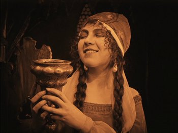 Movie still from “The Golem” (1920), directed by Paul Wegener – A young woman holding a cup in her hands; Close Up shot, High angle