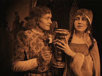 Movie still from “The Golem” (1920), directed by Paul Wegener – A man and a woman standing next to each other; Medium shot, High angle