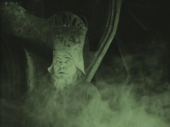 Movie still from “The Golem” (1920), directed by Paul Wegener – An old man with a beard and a hat on his head; Medium shot, Low angle