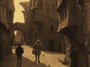 Movie still from “The Golem” (1920), directed by Paul Wegener – A group of people walking down a dirt road; Wide shot, High angle