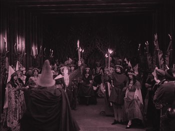 Movie still from “The Golem” (1920), directed by Paul Wegener – A group of people holding lit torches in front of a crowd; Wide shot, High angle