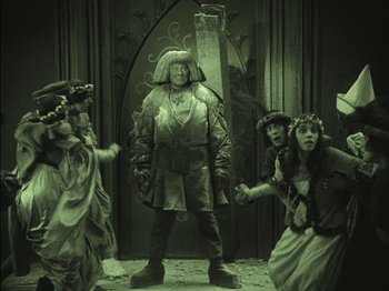 Movie still from “The Golem” (1920), directed by Paul Wegener – A group of people dressed in costumes and posing for a picture; Wide shot, High angle