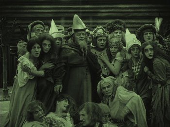 Movie still from “The Golem” (1920), directed by Paul Wegener – A group of people dressed up in costumes; Wide shot, High angle