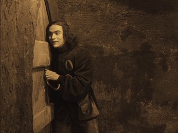 Movie still from “The Golem” (1920), directed by Paul Wegener – A man standing in front of a door; Medium shot, High angle