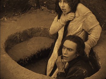 Movie still from “The Golem” (1920), directed by Paul Wegener – A man and a woman are standing next to each other; Medium shot, High angle