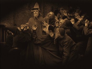 Movie still from “The Golem” (1920), directed by Paul Wegener – A group of people dressed up in costumes; Wide shot, High angle