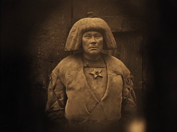 Movie still from “The Golem” (1920), directed by Paul Wegener – A statue of a man wearing a hat and a uniform; Close Up shot, High angle