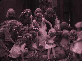 Movie still from “The Golem” (1920), directed by Paul Wegener – A group of children gathered around a woman; Wide shot, High angle