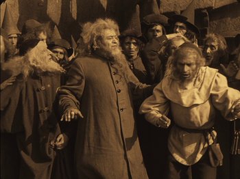 Movie still from “The Golem” (1920), directed by Paul Wegener – A group of people dressed as witches and wizards; Wide shot, High angle