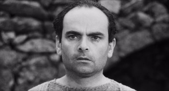 Movie still from “The Gospel According to St. Matthew” (1964), directed by Pier Paolo Pasolini – Black and white photograph of a man in a sweater; Close Up shot, Low angle