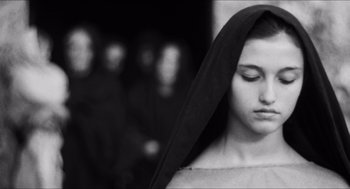 Movie still from “The Gospel According to St. Matthew” (1964), directed by Pier Paolo Pasolini – A woman with her eyes closed wearing a black veil; Close Up shot, Low angle