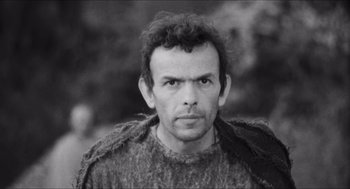 Movie still from “The Gospel According to St. Matthew” (1964), directed by Pier Paolo Pasolini – Black and white photograph of a man in a sweater; Close Up shot, Low angle