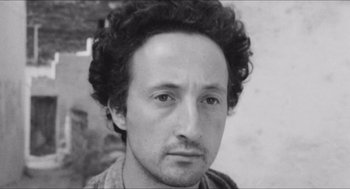 Movie still from “The Gospel According to St. Matthew” (1964), directed by Pier Paolo Pasolini – Black and white photograph of a man with curly hair; Close Up shot, Low angle