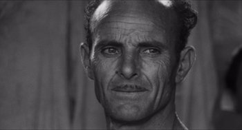 Movie still from “The Gospel According to St. Matthew” (1964), directed by Pier Paolo Pasolini – An older man with a beard and a mustache; Close Up shot, Low angle