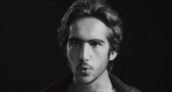 Movie still from “The Gospel According to St. Matthew” (1964), directed by Pier Paolo Pasolini – Black and white photograph of a man with long hair; Close Up shot, Low angle