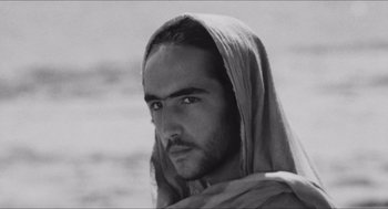 Movie still from “The Gospel According to St. Matthew” (1964), directed by Pier Paolo Pasolini – Black and white photograph of a man with a beard; Close Up shot, Low angle