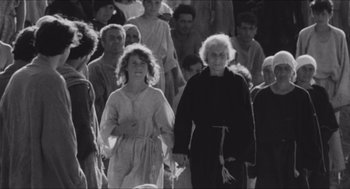 Movie still from “The Gospel According to St. Matthew” (1964), directed by Pier Paolo Pasolini – An older woman and a young girl are walking together; Medium shot, High angle