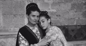 Movie still from “The Gospel According to St. Matthew” (1964), directed by Pier Paolo Pasolini – An older woman and a younger woman posing for a picture; Close Up shot, High angle