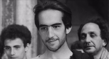 Movie still from “The Gospel According to St. Matthew” (1964), directed by Pier Paolo Pasolini – Black and white photograph of a young man with long hair; Close Up shot, Low angle