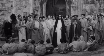 Movie still from “The Gospel According to St. Matthew” (1964), directed by Pier Paolo Pasolini – A black and white photo of a group of people; Wide shot, High angle