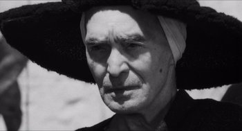 Movie still from “The Gospel According to St. Matthew” (1964), directed by Pier Paolo Pasolini – An old man wearing a hat and a scarf; Close Up shot, Low angle