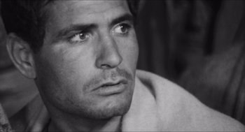 Movie still from “The Gospel According to St. Matthew” (1964), directed by Pier Paolo Pasolini – Black and white photograph of a man looking into the distance; Close Up shot, Over the shoulder angle