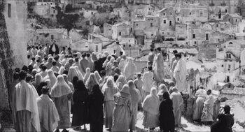 Movie still from “The Gospel According to St. Matthew” (1964), directed by Pier Paolo Pasolini – A black and white photo of a group of people gathered together; Extreme Wide shot, High angle