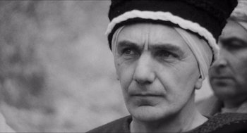Movie still from “The Gospel According to St. Matthew” (1964), directed by Pier Paolo Pasolini – An old man with a bandage on his head; Close Up shot, Low angle