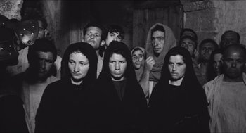 Movie still from “The Gospel According to St. Matthew” (1964), directed by Pier Paolo Pasolini – A black and white photo of a group of people; Medium shot, High angle