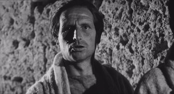 Movie still from “The Gospel According to St. Matthew” (1964), directed by Pier Paolo Pasolini – Black and white photograph of a man with a towel on his face; Close Up shot, Low angle