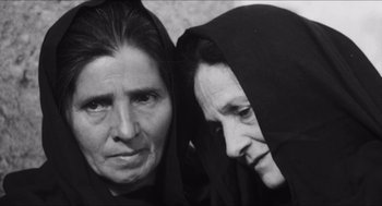 Movie still from “The Gospel According to St. Matthew” (1964), directed by Pier Paolo Pasolini – Two older women wearing black and one is wearing a black veil; Close Up shot, High angle