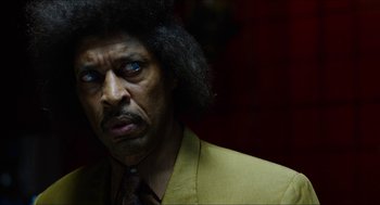 Movie still from “The Greasy Strangler” (2016), directed by Jim Hosking – A person wearing a suit and tie; Close Up shot, Low angle