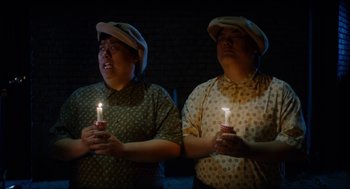 Movie still from “The Greasy Strangler” (2016), directed by Jim Hosking – A couple of people that are holding lit candles; Medium shot, Low angle