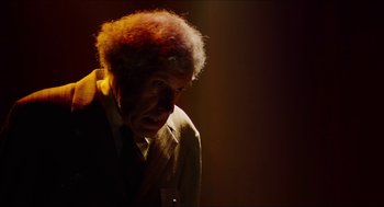 Movie still from “The Greasy Strangler” (2016), directed by Jim Hosking – An old man with a red afro is looking at the camera; Close Up shot, Low angle