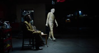 Movie still from “The Greasy Strangler” (2016), directed by Jim Hosking – A man dressed in a yellow suit is walking next to another man in a yellow suit; Wide shot, Low angle