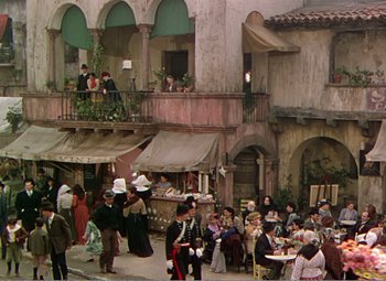 Movie still from “The Great Caruso” (1951), directed by Richard Thorpe – A group of people standing around a building; Extreme Wide shot, High angle